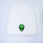 Cappello bianco con risvolto decorato con un logo alieno verde e nero, stile futuristico e originale.