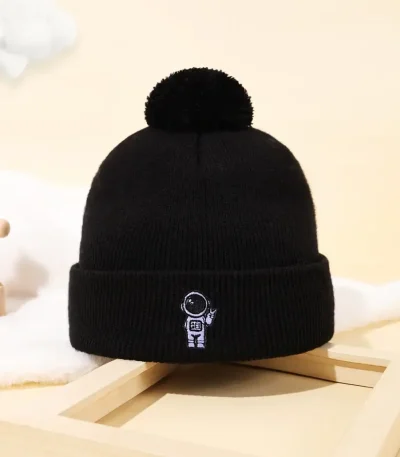 Berretto invernale nero con ricamo di un astronauta e pianeta, perfetto come accessorio decorativo o per appassionati di scienza e spazio.