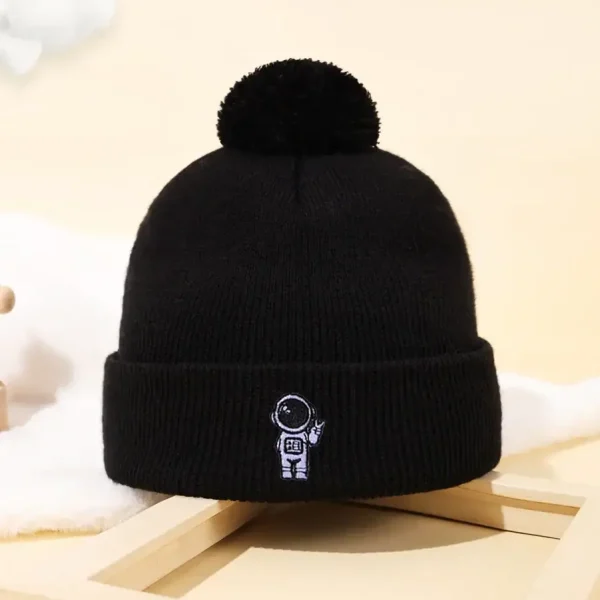 Berretto invernale nero con ricamo di un astronauta e pianeta, perfetto come accessorio decorativo o per appassionati di scienza e spazio.