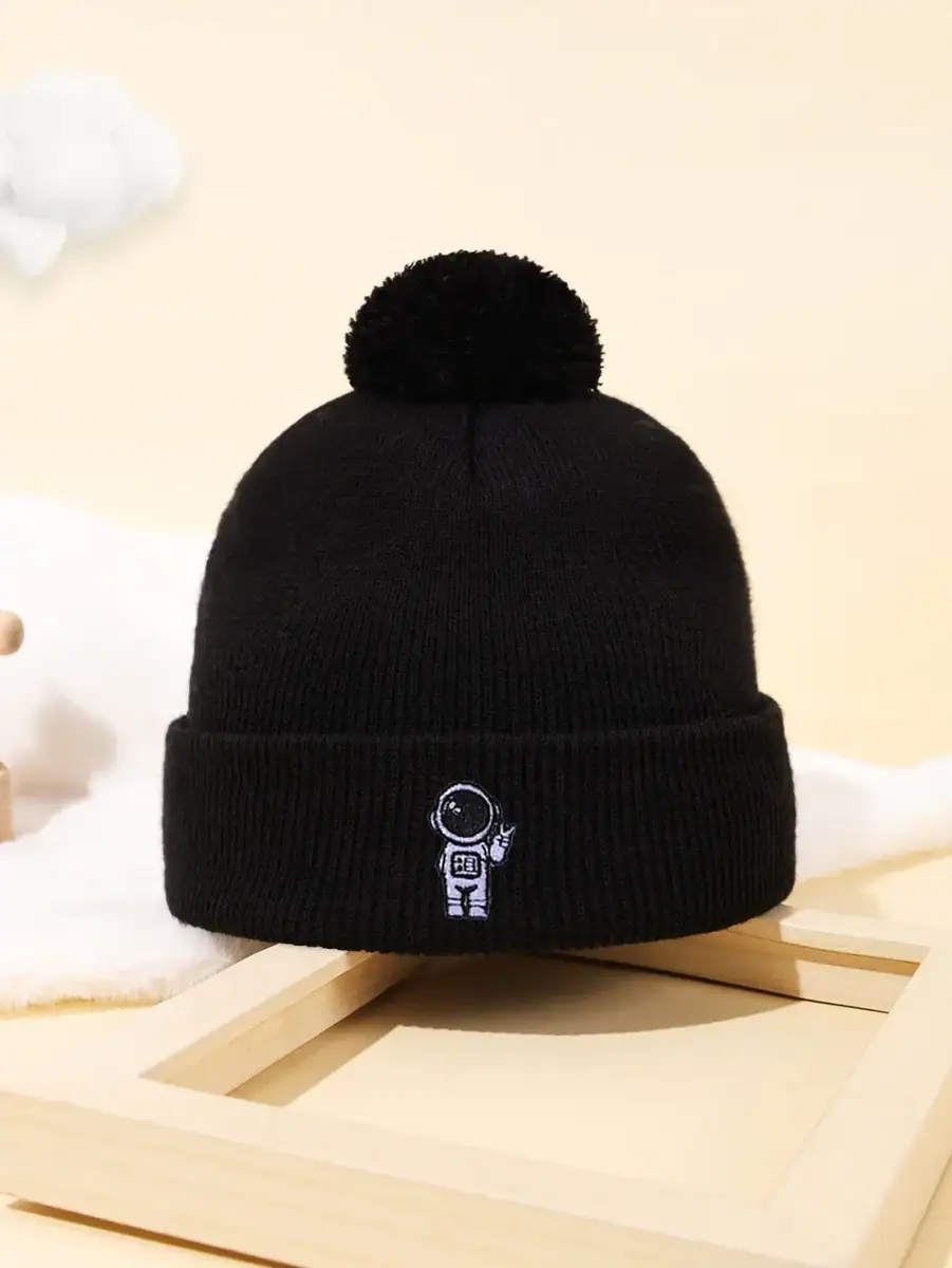 Berretto invernale nero con ricamo di un astronauta e pianeta, perfetto come accessorio decorativo o per appassionati di scienza e spazio.