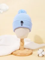 Cappellino invernale azzurro con pompon e stampa di astronauta, perfetto come decorazione scientifica o accessorio per bambini.