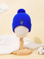 Berretto di lana blu con pompon e ricamo di un piccolo astronauta con casco, ideale per l'inverno e per gli appassionati di scienza e spazio.