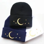 Cappello in maglia con decorazione di luna e stelle ricamate, disponibile in nero, blu e bianco, perfetto per gli appassionati di astronomia e stile casual.