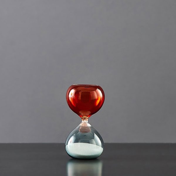 Vaso a clessidra con sabbia rossa e cristallo trasparente, simbolo di tempo e scienza, perfetto come decorazione scientifica elegante e originale.