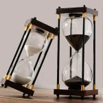 Orologio a sabbia decorativo in stile scientifico con struttura in legno e vetro, perfetto come oggetto di arredamento originale e elegante per ambienti moderni e studi.