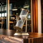 Orologio a clessidra decorativa in stile vintage con base in metallo e vetro, perfetto come oggetto di decorazione scientifica o da scrivania. Ideale per appassionati di scienza e design retrò.