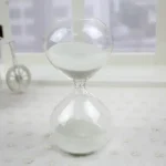 Clessidra decorativa in vetro con sabbia bianca, perfetta come oggetto scientifico o decorativo, ideale per ambienti moderni e minimalisti.