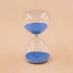 Orologio a sabbia decorativo con sabbia blu, perfetto come oggetto scientifico e decorativo per ambienti educativi o moderni.