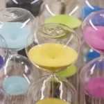 Orologio a sabbia decorativo colorato con vetro trasparente e sabbia di vari colori, ideale come oggetto decorativo per case e uffici, simbolo di tempo e relax.