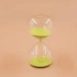 Clessidra decorativa con sabbia verde in vetro trasparente, simbolo di tempo e pazienza, ideale come oggetto decorativo scientifico.