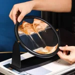 Piatto di sabbia con effetto ondulato e riflessi di luce, utilizzato per decorazioni scientifiche e attività educative.