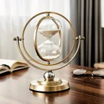 Orologio a sabbia decorativo con struttura in metallo dorato e clessidra in vetro, perfetto come oggetto di arredamento scientifico e decorativo.