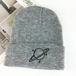 Cuffia grigia con simbolo di pianeta e anello, ideale per appassionati di astronomia e scienza. Perfetta per l'inverno, combina stile e passione scientifica.