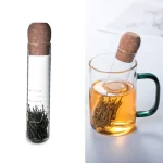 Test di infusione con erbe aromatiche in un bicchiere trasparente, evidenziando il processo di estrazione di aromi naturali.