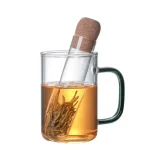 Provetta di laboratorio con liquido dorato e campione di erba secca immerso, simbolo di scienza e ricerca.