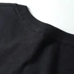Maglietta nera in cotone con dettaglio sul collo, semplice e versatile, perfetta per ogni occasione casual.