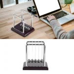 Péndolo di Newton in miniatura con cinque sfere metalliche, posizionato su una base nera, ideale come oggetto decorativo scientifico e strumento educativo.