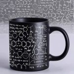 Tazza nera con disegni di formule chimiche e simboli scientifici bianche, perfetta per appassionati di scienza e decorazioni a tema scientifico.