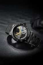 Orologio da uomo con movimento scheletrato, cinturino in acciaio nero e dettagli dorati, perfetto per appassionati di orologeria e design innovativo.