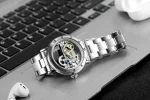 Orologio da tavolo con design meccanico visibile, cassa in metallo e movimento scheletrato, ideale come decorazione scientifica e oggetto di interesse per appassionati di orologeria.