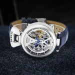 Orologio scheletrato con movimento visibile, cinturino in pelle blu e cassa in acciaio, perfetto come oggetto decorativo e da collezione scientifica.
