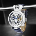 Orologio meccanico con cassa trasparente e dettagli visibili, cinturino in pelle blu, perfetto come decorazione scientifica e oggetto di design innovativo.
