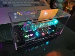 Display LED scientifico in scatola trasparente con luci colorate e componenti elettronici visibili.