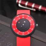 Orologio da polso con quadrante ispirato a strumenti scientifici, con lancette che ricordano componenti di apparecchiature di laboratorio, cinturino rosso vivace.