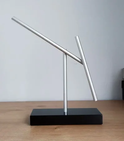 Scultura di Penrose in metallo con forma piramidale, simbolo di illusione ottica e matematica, su base nera, perfetta come decorazione scientifica moderna.
