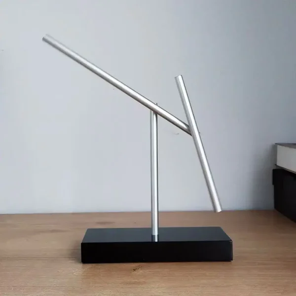 Scultura di Penrose in metallo con forma piramidale, simbolo di illusione ottica e matematica, su base nera, perfetta come decorazione scientifica moderna.