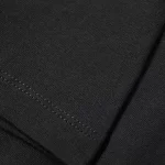 Dettaglio di una maglietta nera con cuciture invisibili, perfetta per un look minimalista e moderno. Ideale per chi cerca comfort e stile in un capo versatile.