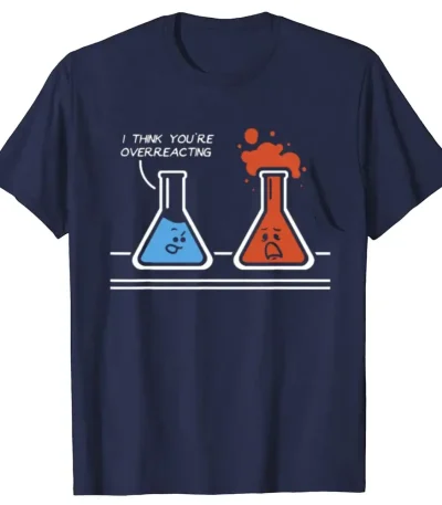 T-shirt blu con disegno di due provette con facce animate, una triste e una felice, con il testo "I think you're overreacting". Design umoristico e originale per appassionati di scienza.