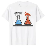 T-shirt con disegno di due beute di laboratorio con facce sorridenti, una blu e una rossa, con la scritta "I think you're overreacting".