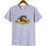 Maglietta grigia con stampa di un cubo di Rubik che sembra sciogliersi, perfetta per gli appassionati di giochi di logica e design originale.