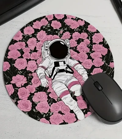 Oggetto decorativo a tema spaziale con figura di astronauta su tappetino rosa con rose.