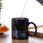 Tazza nera con disegni di costellazioni e simboli zodiacali di Leone e Ariete, perfetta per gli appassionati di astronomia e astrologia, ideale come oggetto decorativo o regalo.