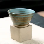 Vaso decorativo in ceramica con base in cemento, perfetto come oggetto scientifico o decorativo, con finitura a righe azzurre e beige.