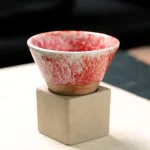 Piatto di ceramica con base in cemento, decorato con motivo rosso, ideale come oggetto decorativo scientifico o da collezione.