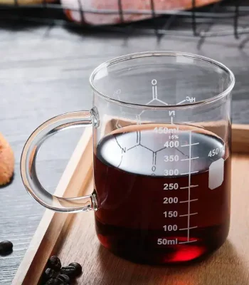 Vaso graduato in vetro con liquido scuro, ideale come oggetto decorativo o da collezione scientifica.
