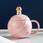 Tazza decorativa a forma di pianeta con astronauta dorato sulla sommità, perfetta come oggetto di decorazione scientifica o regalo originale per appassionati di spazio e astronomia.