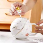 Tazza a forma di pianeta con coperchio a tema spaziale, decorata con stelle e pianeti, perfetta per gli appassionati di astronomia e decorazioni scientifiche.