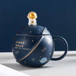 Tazza a forma di pianeta con decorazione astronauta dorato, tema spaziale, perfetta come oggetto decorativo o regalo a tema astronomico.