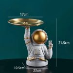 Statua decorativa di un astronauta con piattino dorato, altezza 21,5 cm, perfetta come oggetto di decorazione scientifica o da collezione.