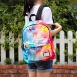 Zaino con stampa galassia colorata, perfetto come decorazione scientifica o accessorio di moda, indossato da una ragazza con sfondo di piante e recinzione in legno.