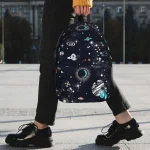 Zaino con design a tema spaziale, stelle, pianeti e galassie, ideale per appassionati di astronomia e decorazioni scientifiche.