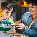 Bambina e donna che giocano con uno strumento scientifico educativo, stimolando curiosità e apprendimento sulla scienza in modo divertente e interattivo. Perfetto per decorazioni e oggetti scientifici.