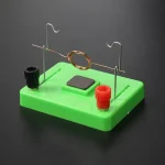 Modello di circuito scientifico con anello di rame, morsetti e base verde, ideale per esperimenti di elettromagnetismo.