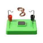 Modello scientifico con bobine di rame, magnete e base verde, ideale per esperimenti di elettromagnetismo e studi di fisica.