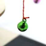 Vetrino di laboratorio con liquido verde brillante sospeso in aria, utilizzato in esperimenti scientifici e decorazioni a tema scientifico.