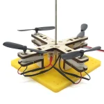 Modello di drone fai-da-te con motori, pale e struttura in plastica, montato su base gialla, ideale per progetti educativi e sperimentazioni scientifiche.